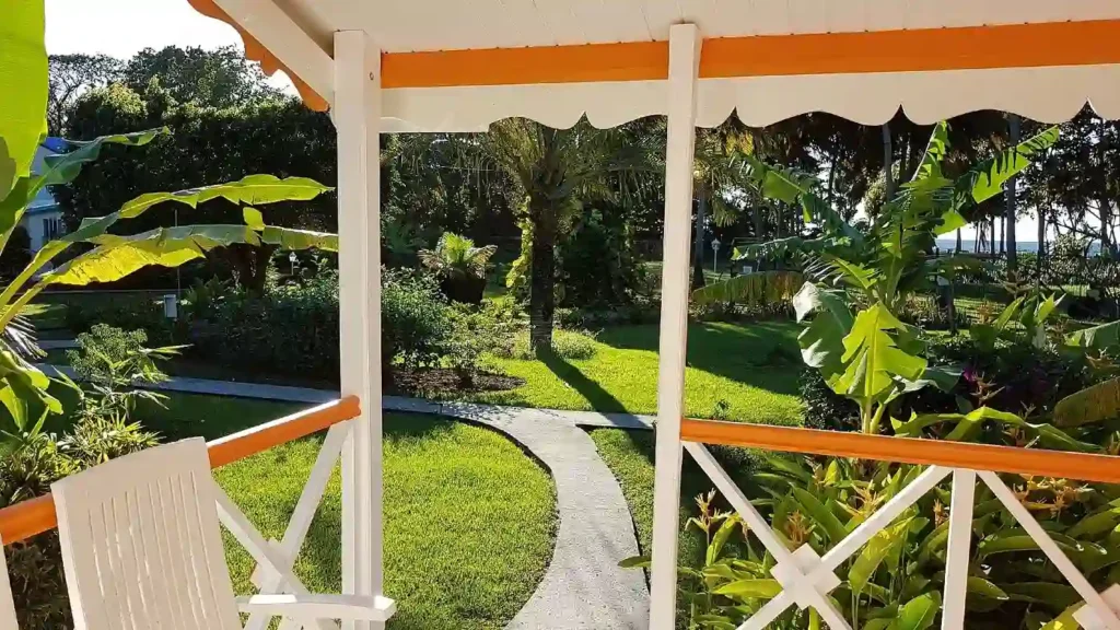 Vue sur le Jardin tropical depuis le Bungalow. Fleurs des iles à Deshaies