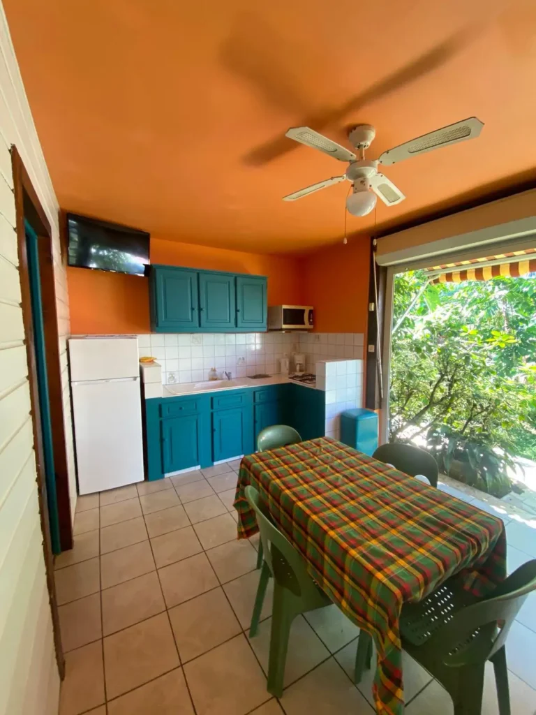 La cuisine et le coin repas ouvert sur le jardin tropical des studios Villa Bagatelle à Sainte-Rose Guadeloupe